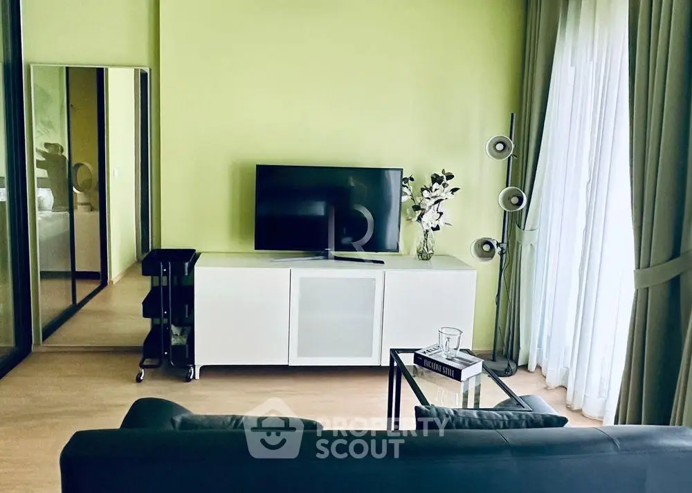 Modern living room with sleek TV setup and stylish decor in a bright apartment.