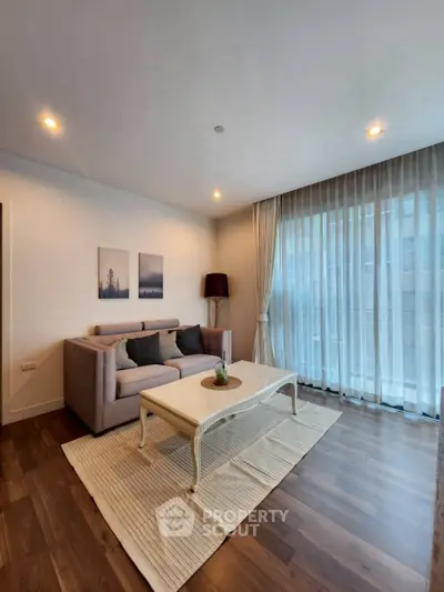 Elegant living room with cozy sofa and large window, perfect for relaxation.