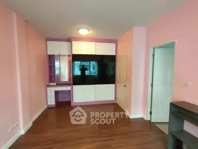 Spacious bedroom with built-in wardrobe and hardwood floors in modern apartment.