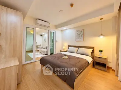 Modern bedroom with wooden flooring and cozy decor in a stylish apartment.