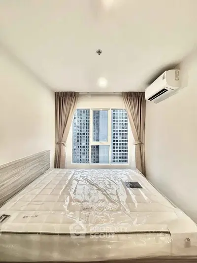 Modern bedroom with large window and air conditioning in high-rise apartment.