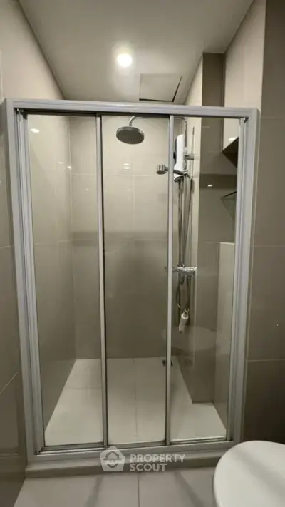 Modern bathroom with sleek shower enclosure and overhead rain showerhead.