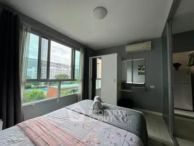 Cozy bedroom with large window and scenic view, featuring modern decor and air conditioning.