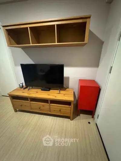 Cozy living room with wooden TV stand and wall-mounted shelves, perfect for modern living.
