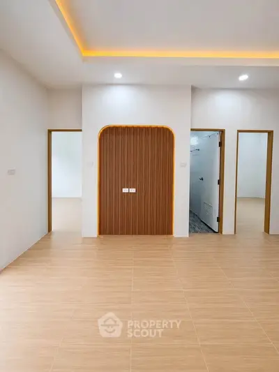 Modern interior with stylish wooden accents and recessed lighting, showcasing a spacious and inviting living area.