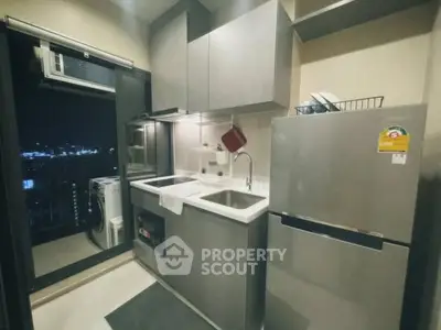 Modern kitchen with sleek appliances and balcony view in urban apartment