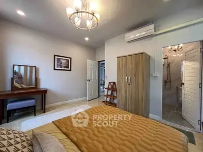 Spacious bedroom with ensuite bathroom and elegant decor in modern apartment.