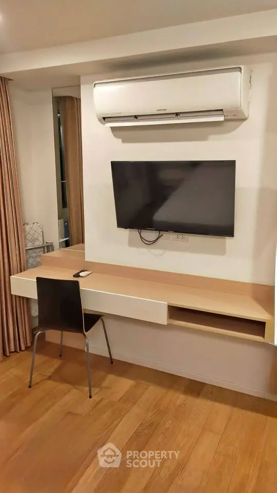 Modern study area with wall-mounted TV and air conditioning in stylish apartment.