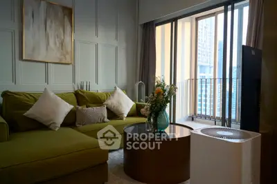Stylish living room with green sofa and city view balcony, perfect for urban living.