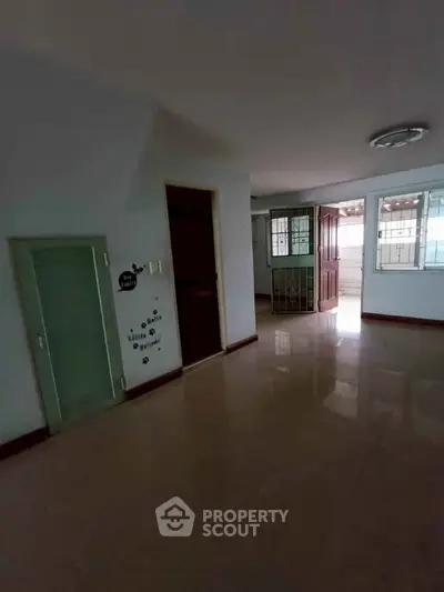 Spacious interior with glossy floors and ample natural light, ideal for modern living.