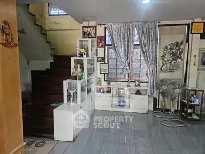 Charming living room with staircase and decorative elements, perfect for cozy family gatherings.