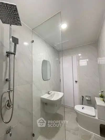 Modern bathroom with sleek shower and elegant fixtures in contemporary home.