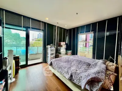 Spacious bedroom with large windows and balcony access in modern apartment