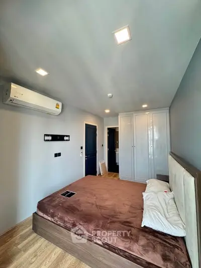 Modern bedroom with stylish decor and ample storage in a contemporary apartment.
