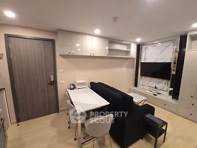 Modern living room with sleek furniture and wall-mounted TV in stylish apartment.