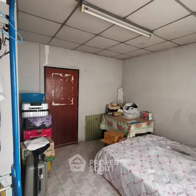 Cozy bedroom with tiled floor and simple furnishings, ideal for budget-conscious buyers.