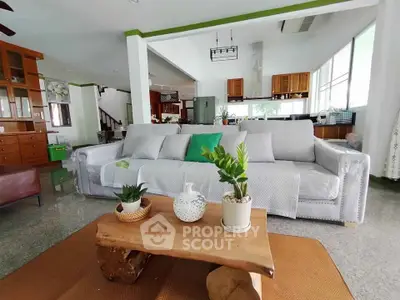 Spacious living room with modern decor and open layout, featuring a cozy sofa and stylish wooden coffee table.