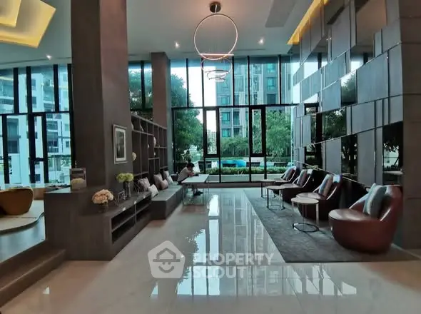 Luxurious modern lobby with elegant seating and floor-to-ceiling windows offering garden views.