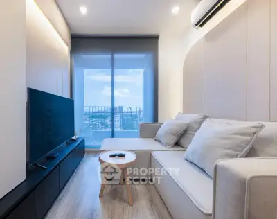 Modern living room with sleek design and city view balcony, featuring cozy sofa and flat-screen TV.