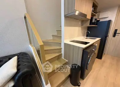 Modern compact kitchen with washing machine and staircase in stylish apartment