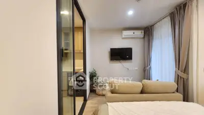 Modern living room with cozy sofa, wall-mounted TV, and large window with curtains.