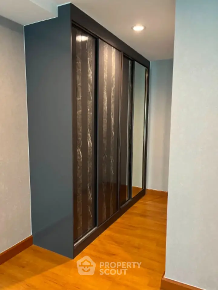 Modern hallway with sleek sliding closet doors and wooden flooring