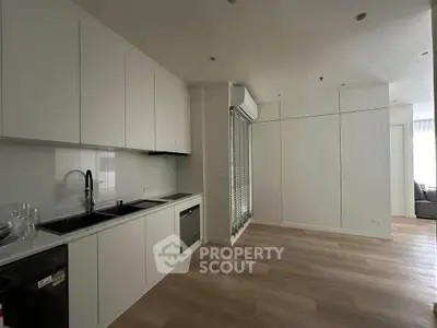 Modern kitchen with sleek cabinetry and built-in appliances in a minimalist apartment.