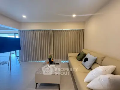 Spacious living room with modern decor and large windows for natural light.
