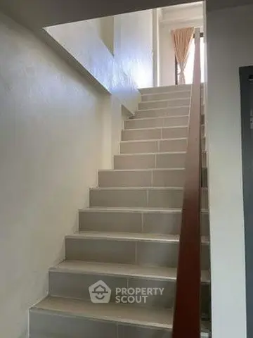 Modern staircase with sleek design and natural light in a contemporary home.