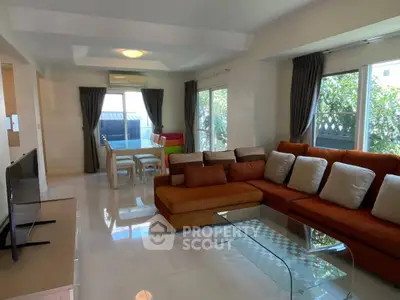 Spacious living room with modern furniture and large windows offering natural light.
