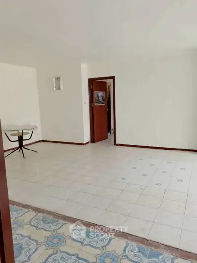 Spacious empty room with tiled flooring and open doorway, ideal for customization.