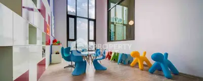 Modern living room with vibrant furniture and floor-to-ceiling windows offering city views.