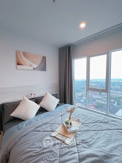 Modern bedroom with large windows offering stunning city views and elegant decor.