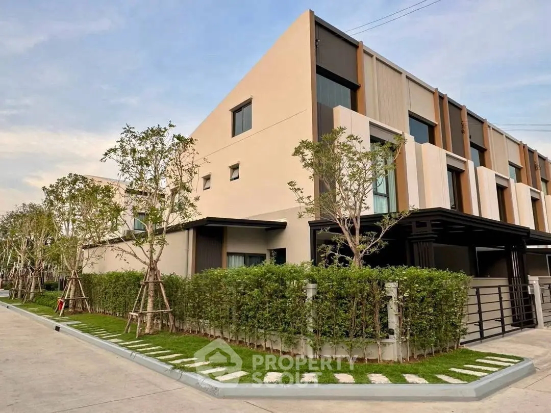 Modern townhouse exterior with lush landscaping and contemporary design.