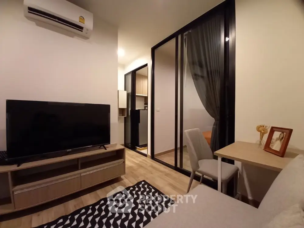 Modern living room with TV, air conditioning, and stylish decor in cozy apartment.