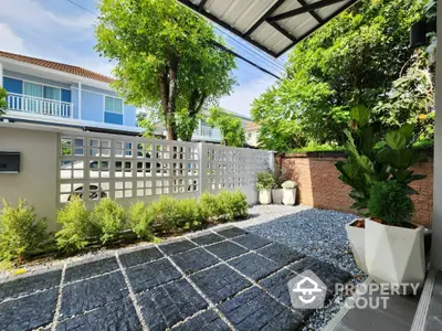 Charming garden patio with modern pavers and lush greenery in a serene residential area.