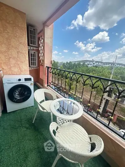 Charming balcony with scenic view, featuring outdoor seating and washing machine, perfect for relaxation.