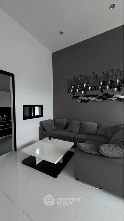 Modern living room with sleek gray sofa and stylish wall art