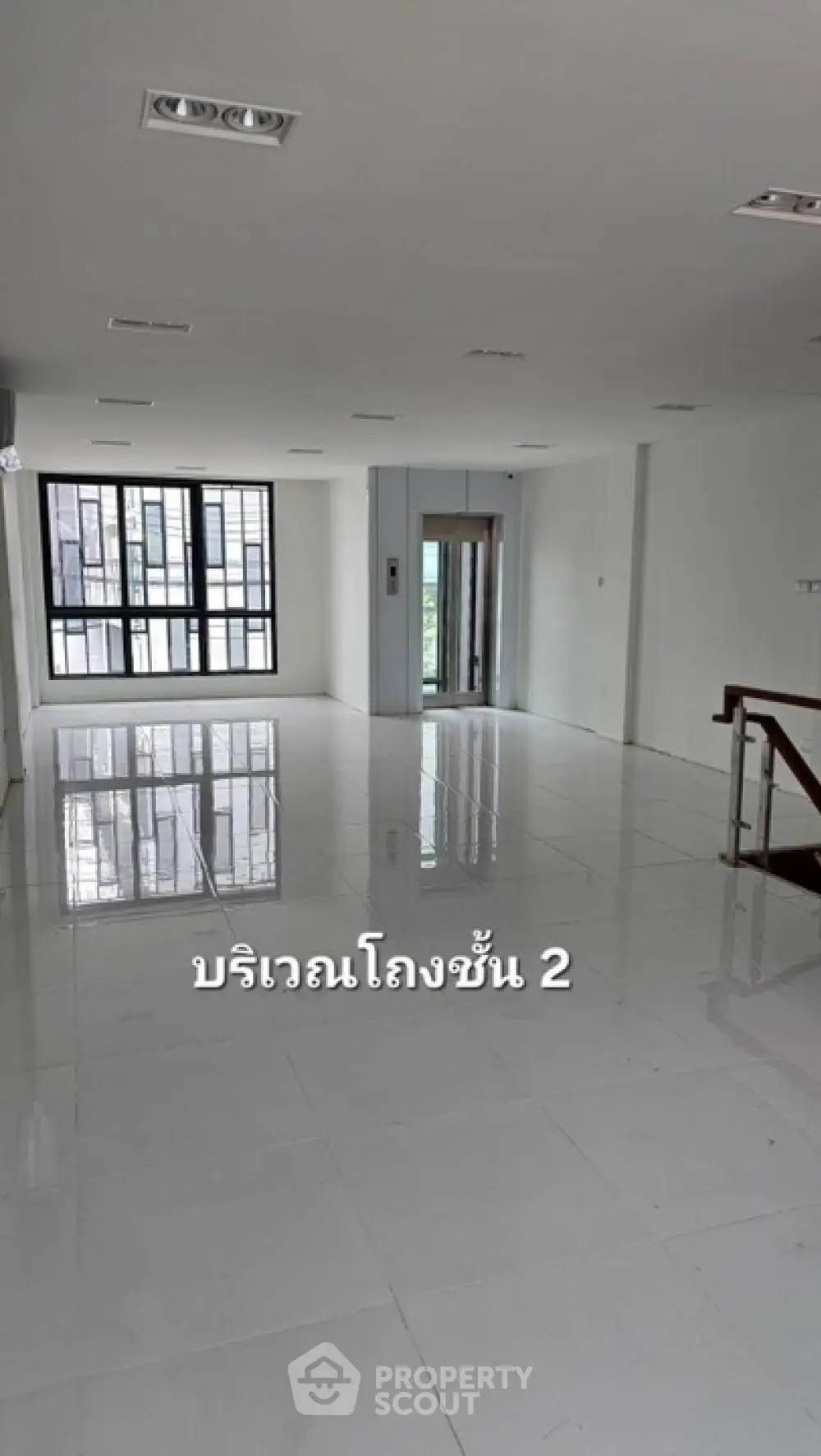 Spacious and bright open-plan living area with glossy tiled floors, large windows, and modern lighting fixtures, ideal for luxurious urban living.