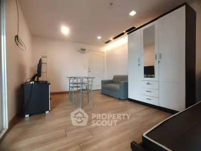 Modern living room with sleek furniture and wooden flooring in a cozy apartment.