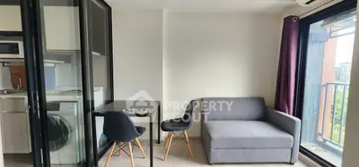 Modern living room with sleek furniture and glass partition in a stylish apartment.