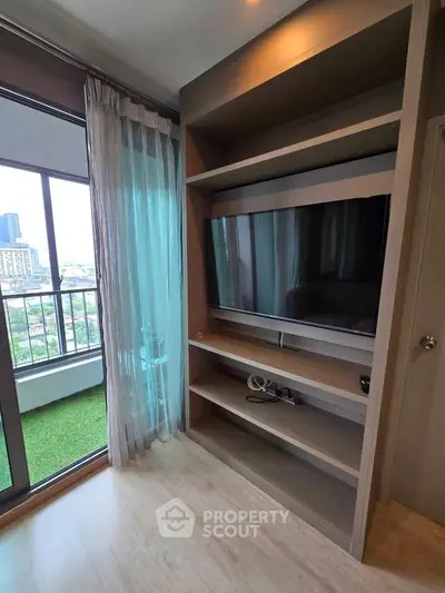 Modern living room with large TV and balcony view in urban apartment