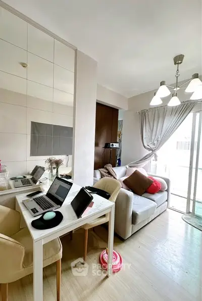 Modern living room with cozy seating and natural light, perfect for relaxation and work-from-home setup.