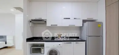 Modern compact kitchen with appliances in sleek white cabinetry