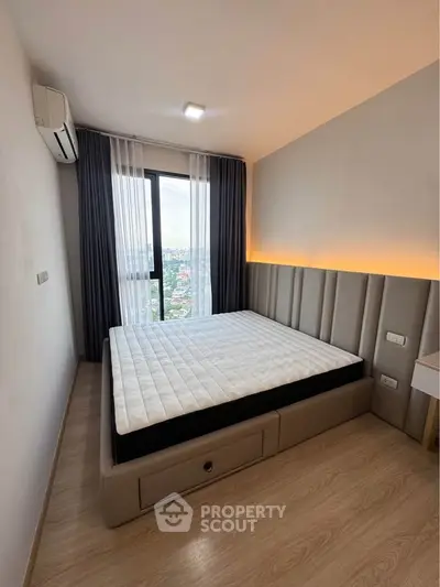 Modern bedroom with city view, featuring sleek design and ample natural light.