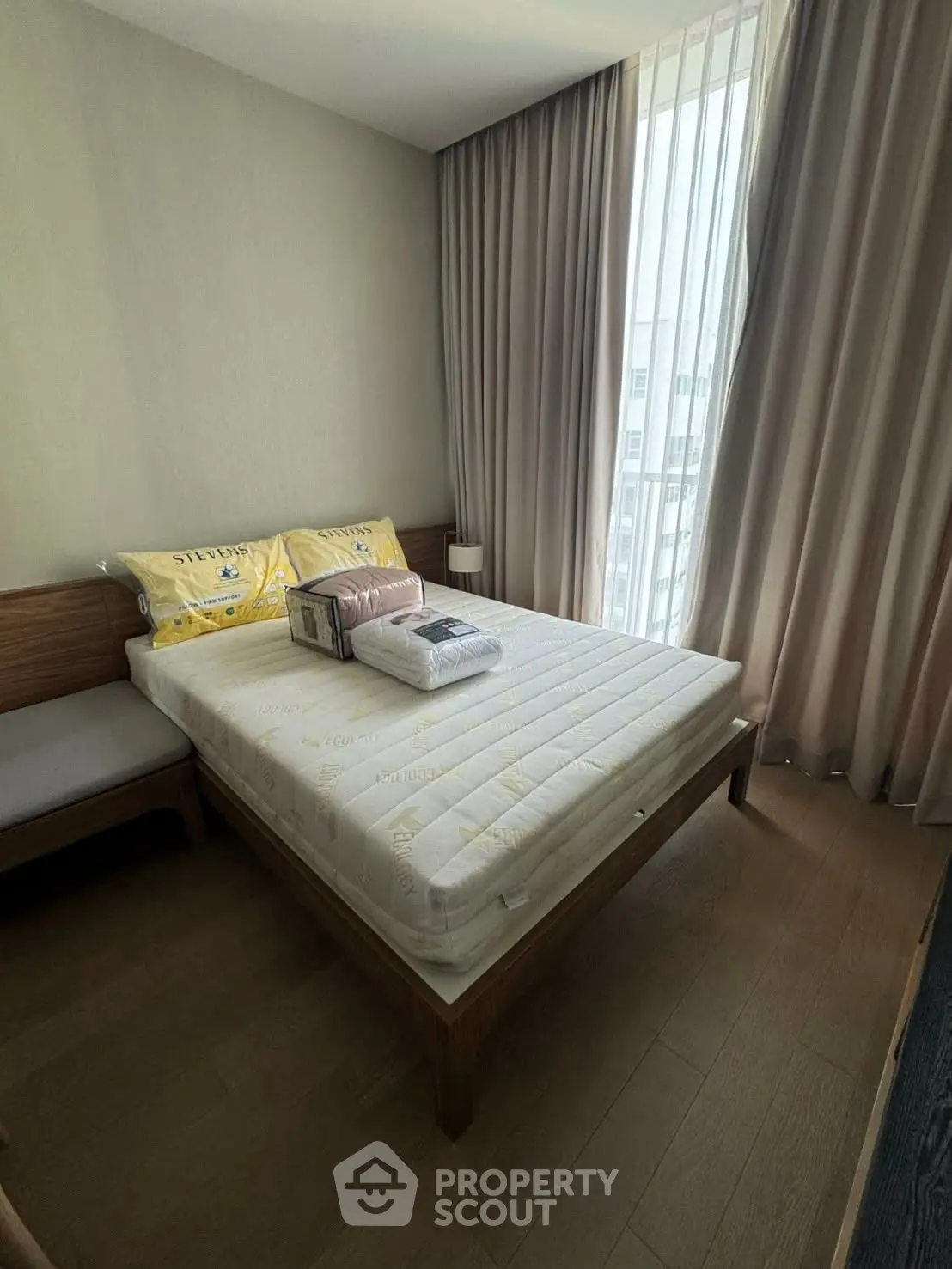 Cozy bedroom with natural light and modern furnishings in a stylish apartment.