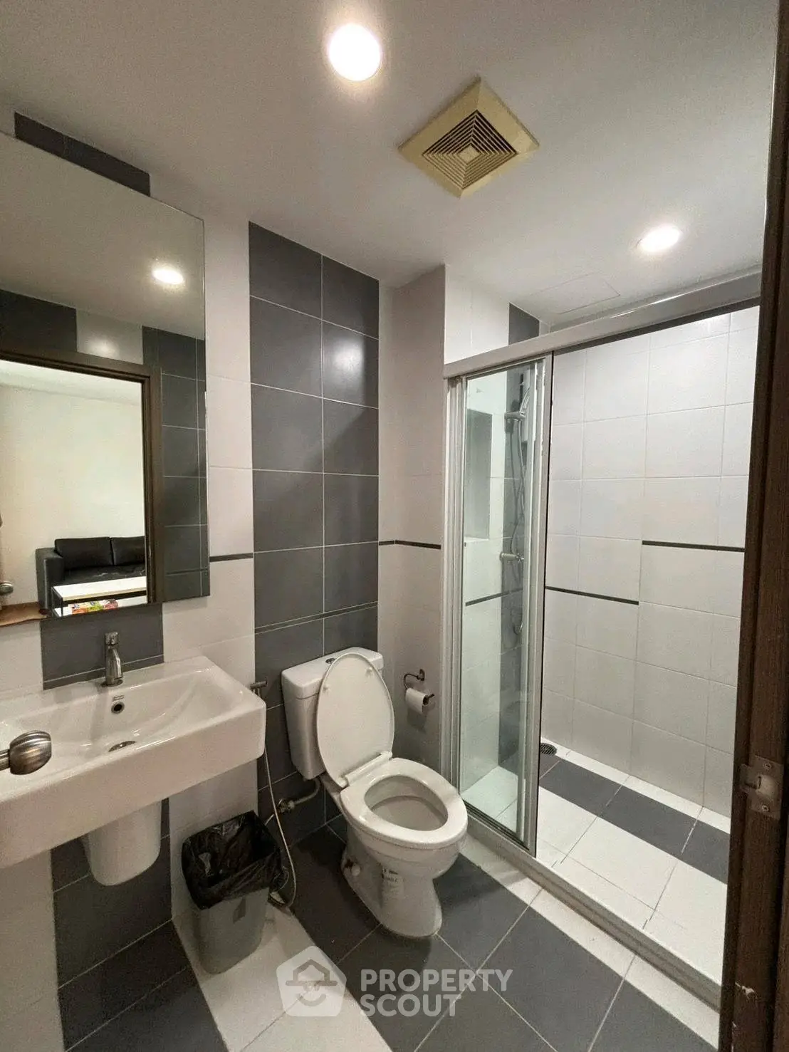 Modern bathroom with sleek design, featuring a glass shower enclosure and contemporary fixtures.