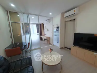 Modern living room with glass partition, sleek furniture, and air conditioning.