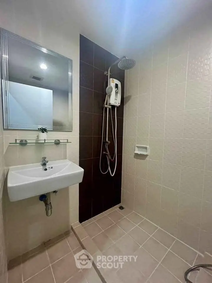 Modern bathroom with sleek shower and sink in a minimalist design.