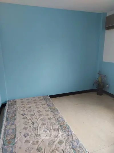 Minimalist bedroom with blue walls and simple bedding, ideal for a cozy living space.